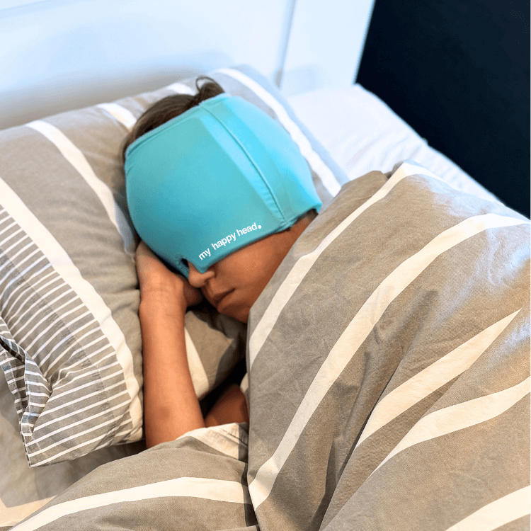 Barn som sover med turkos huvudvärksmössa från My Happy Head som ger kylande lindring vid huvudvärk, smärta och spänningar.