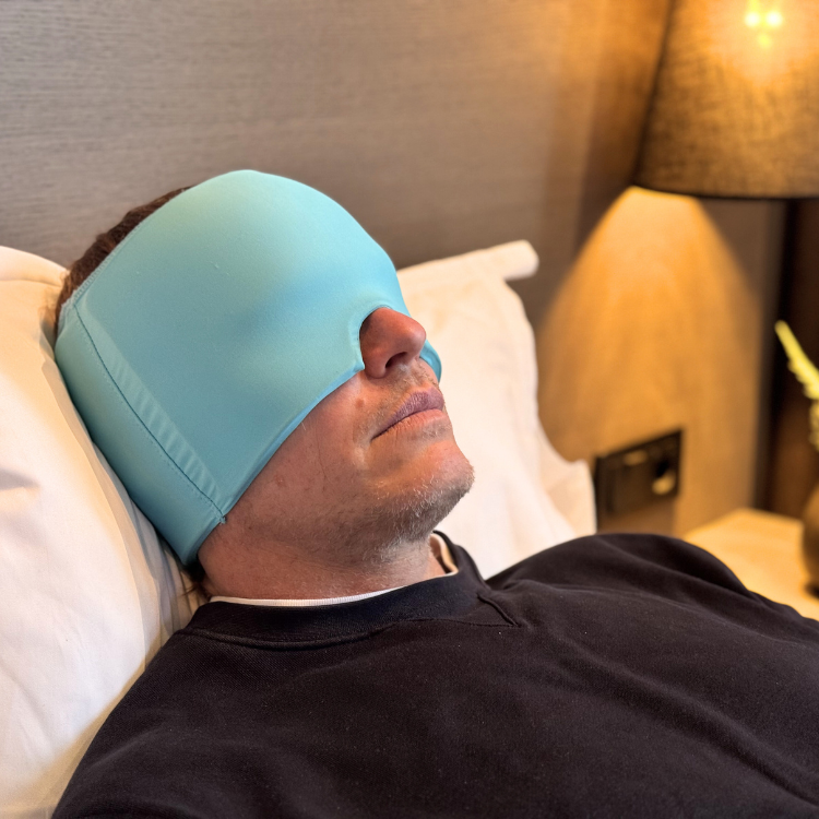 Man som vilar med turkos huvudvärksmössa från My Happy Head för att lindra huvudvärk och spänningar med kylande effekt.